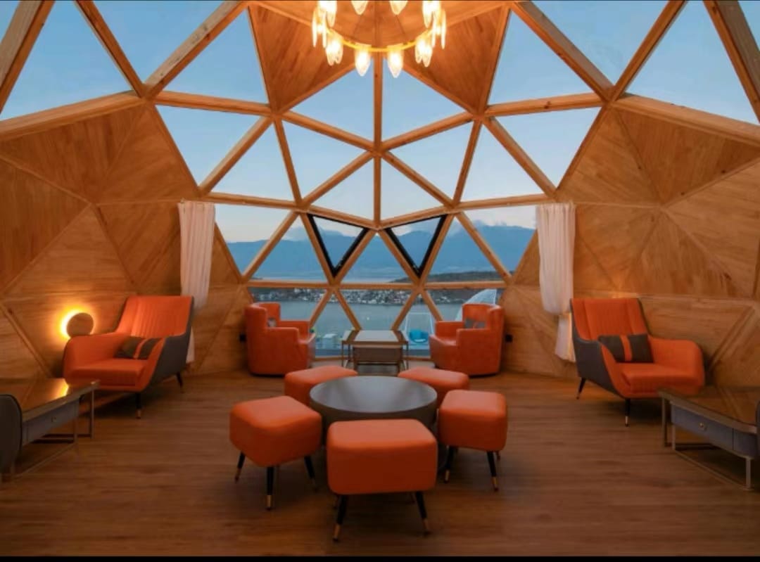 Real Solaris dome pod lounge with orange seating, chandelier and mountain view